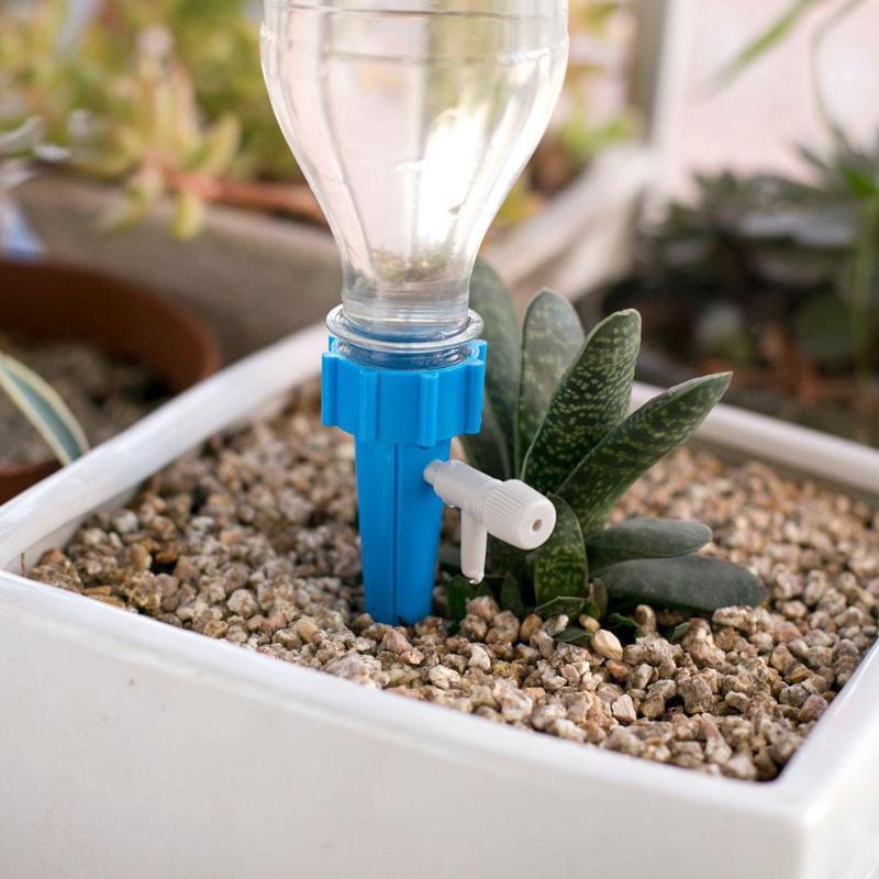 Adjustable self-watering spike attached to an upturned plastic bottle in a plant pot