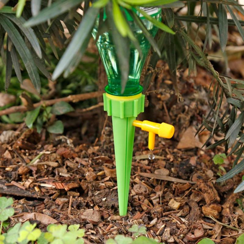 Adjustable self-watering spike attached to an upturned plastic bottle in a plant pot