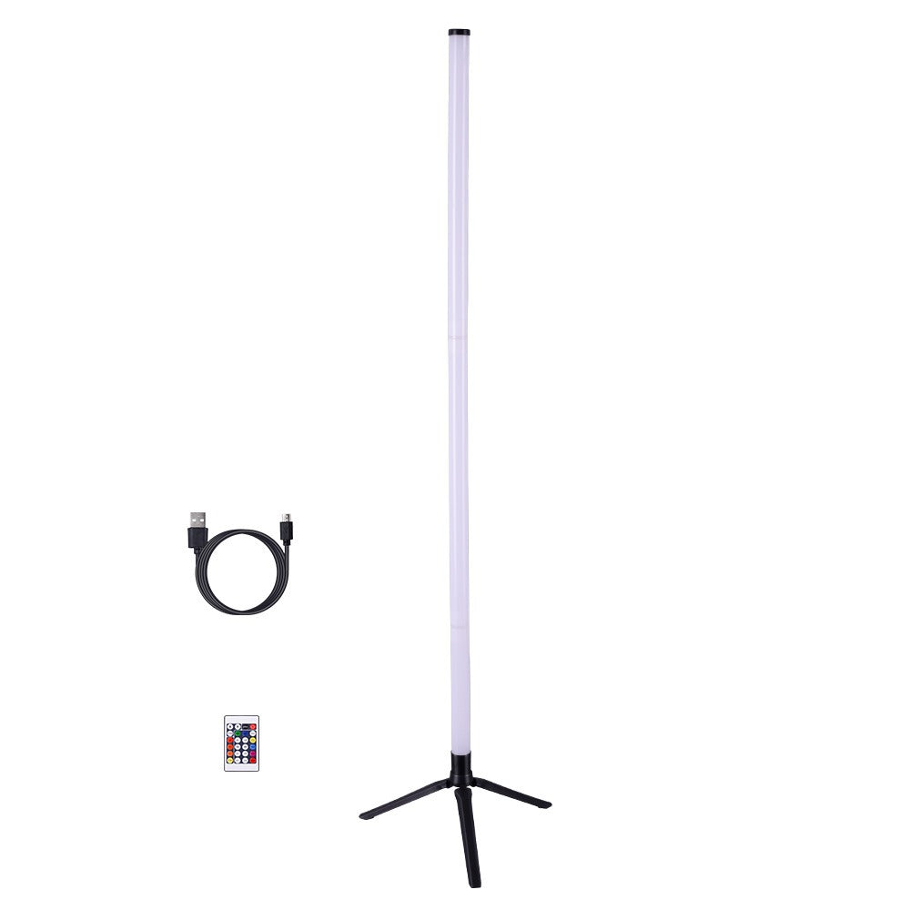Slim RGB LED corner floor lamp on a tripod stand glowing in colour