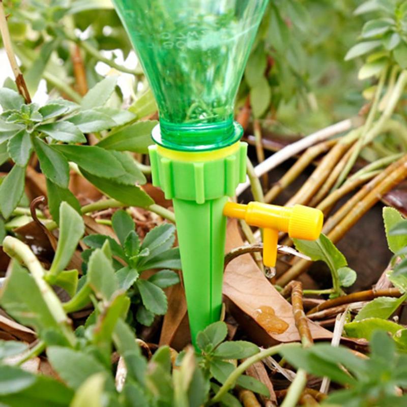 Adjustable self-watering spike attached to an upturned plastic bottle in a plant pot
