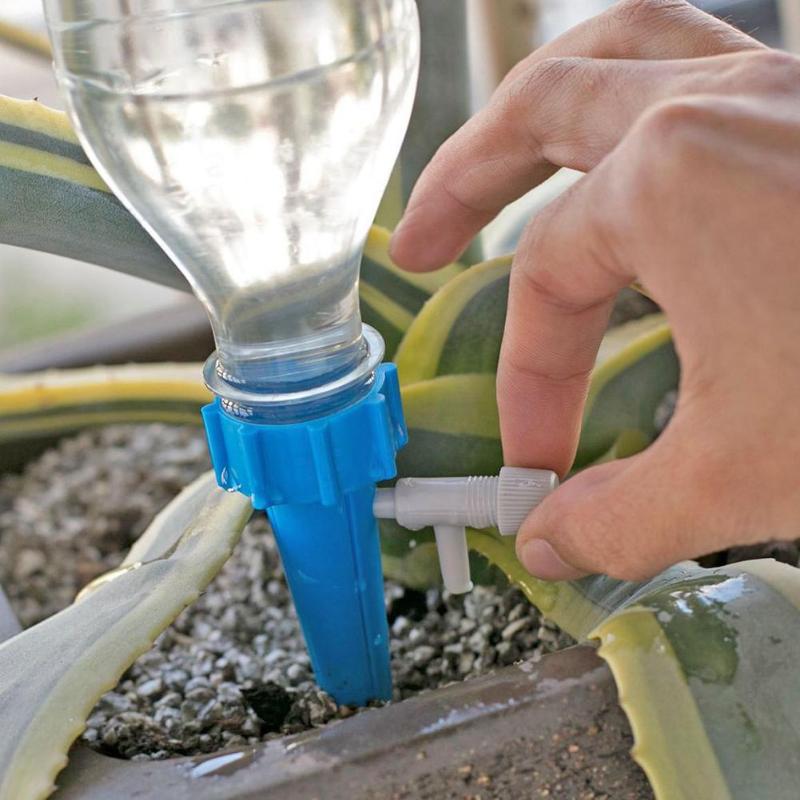 Adjustable self-watering spike attached to an upturned plastic bottle in a plant pot