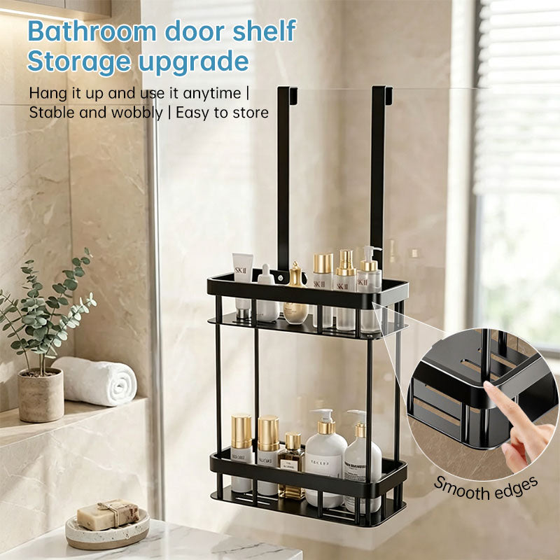 Black double layer shower caddy hanging over a glass shower door holding toiletries