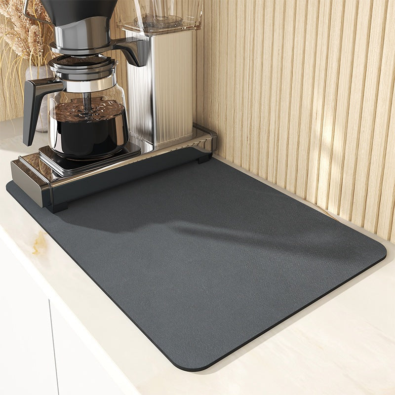 Dark grey draining mat under a coffee machine