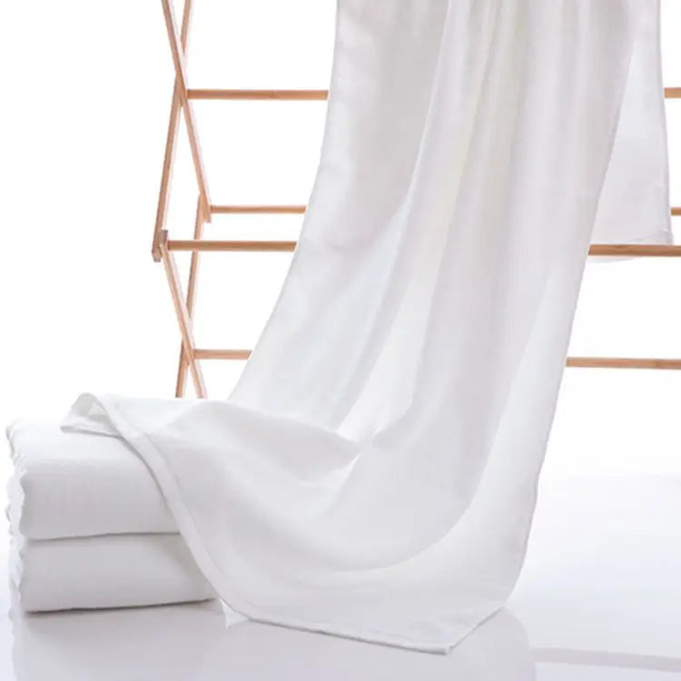 Large white cotton bath towel on a drying rack