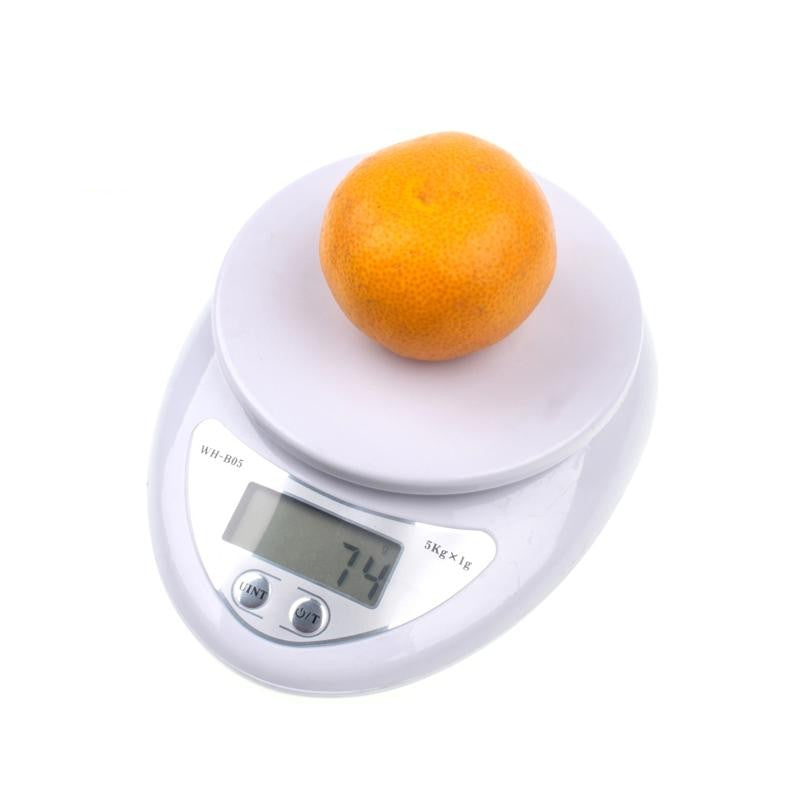 Compact digital kitchen scale weighing an orange